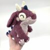 Pink dragon held in a hand